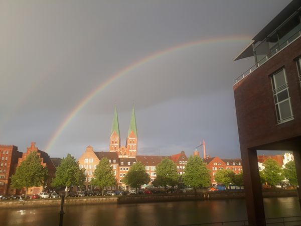 Blick über die Trave auf die Lübecker Altstadt unter einem doppeltem Regenbogen